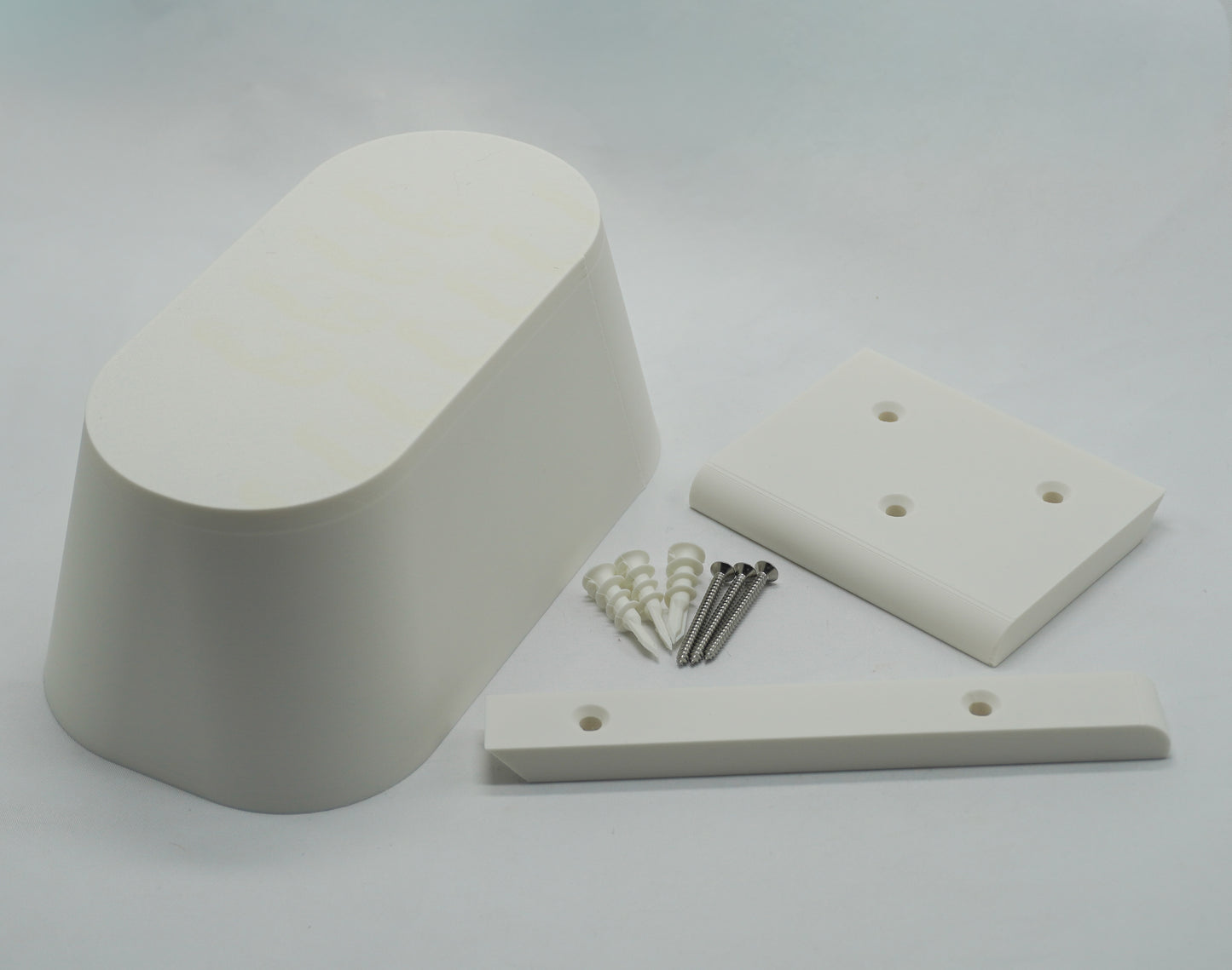Couch Spacer kit contents: pill-shaped spacer, wall rails, mounting screws, and drywall anchors