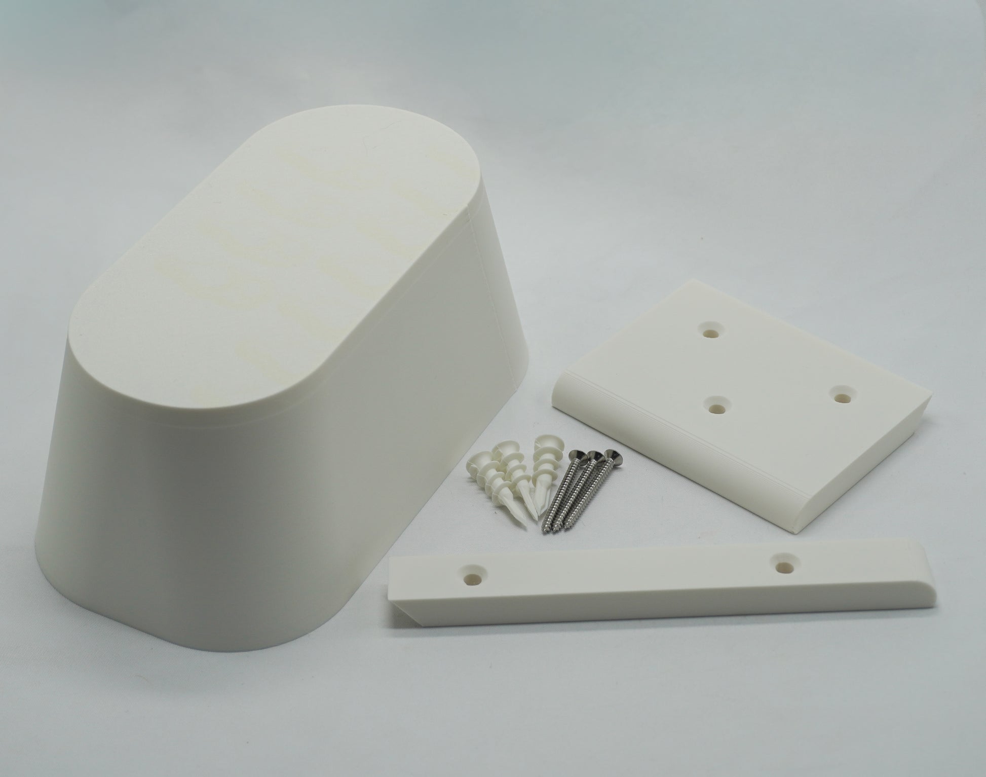 Couch Spacer kit contents: pill-shaped spacer, wall rails, mounting screws, and drywall anchors